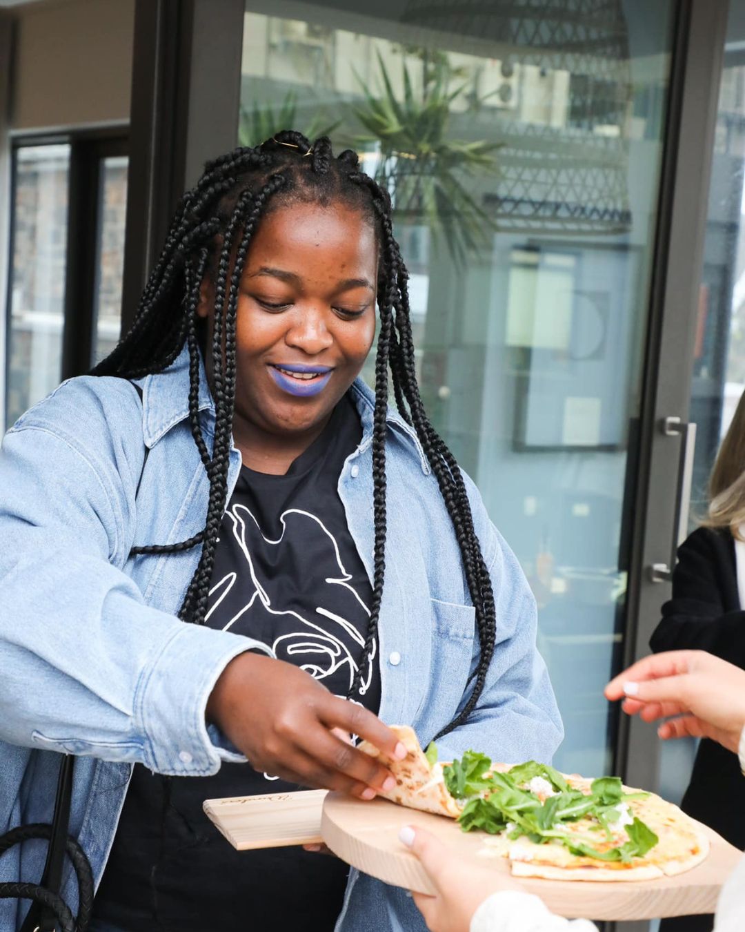 A guest taking a slice of wood-fired pizza at an event