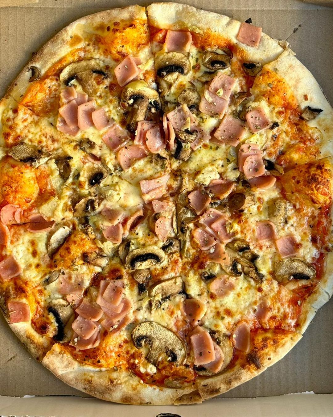 Ham and mushroom wood-fired pizza straight out of the oven